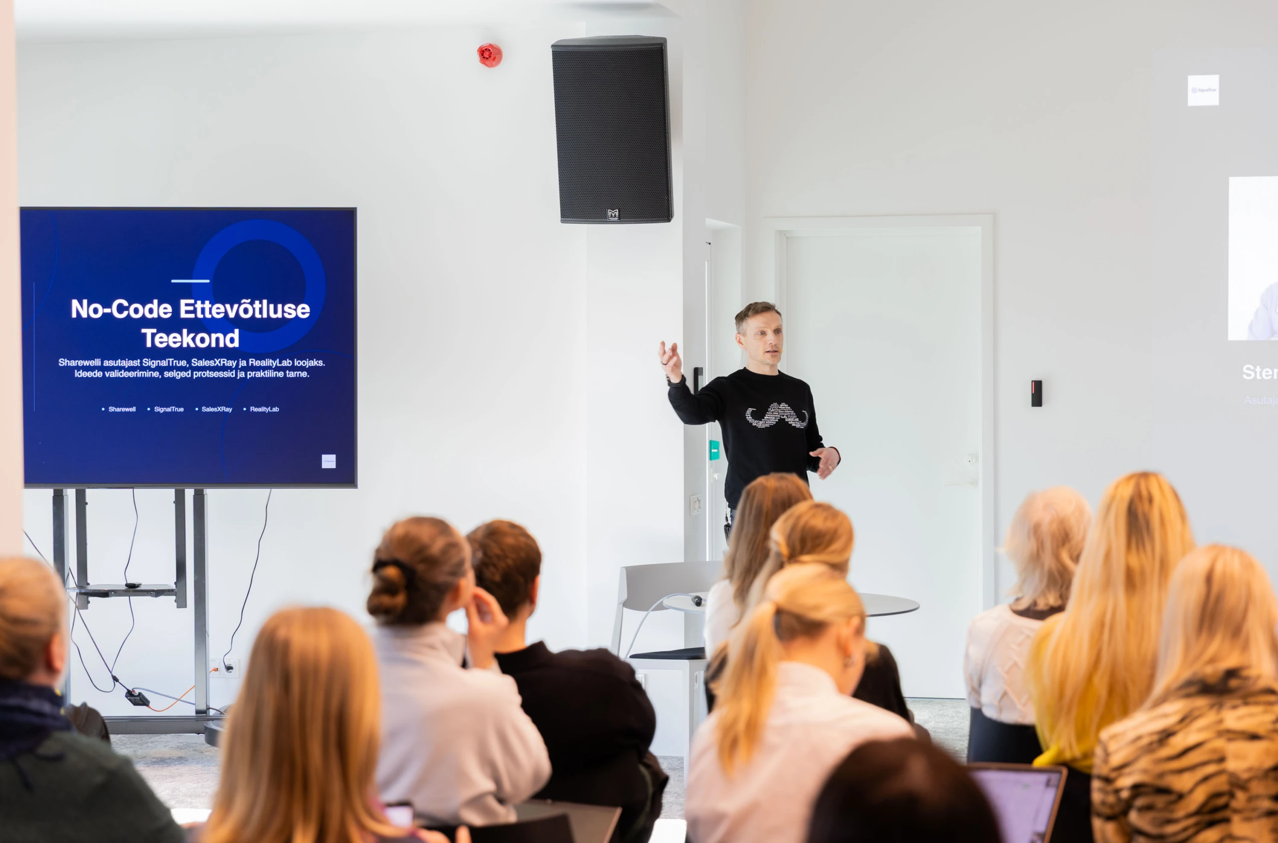 Sten Kreisberg speaking at Tallinna Ettevõtlusinkubaator with the presentation screen and audience visible, 5 March 2026.